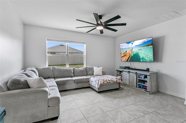 living room featuring ceiling fan and a textured ceiling