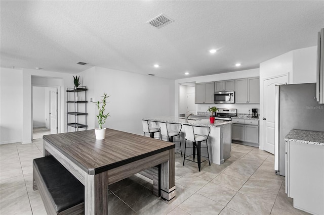 tiled dining space with sink and a textured ceiling