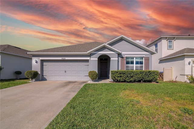 view of front of house featuring an attached garage, driveway, roof with shingles, stucco siding, and a front yard