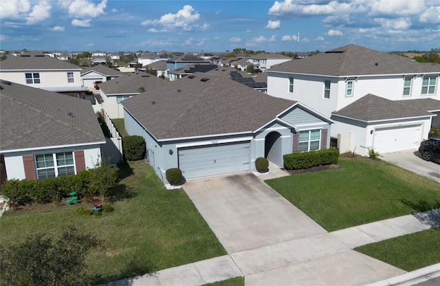 traditional home with a residential view, concrete driveway, and a front yard