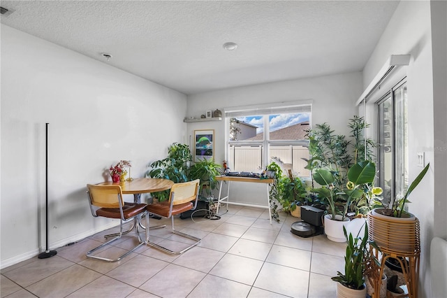 dining space featuring visible vents, a textured ceiling, baseboards, and light tile patterned flooring