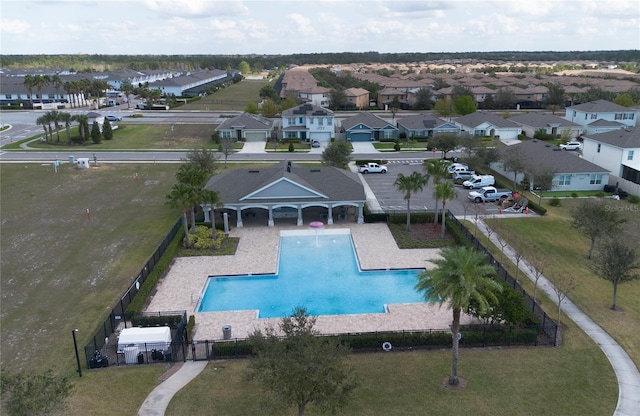 pool with a patio area, fence, and a residential view