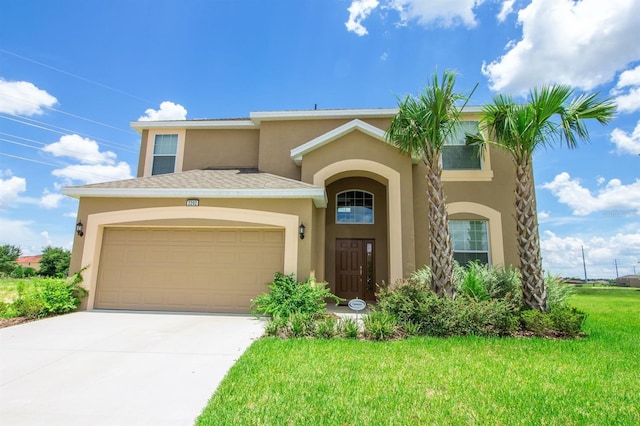 view of front of house with a garage, driveway, a front lawn, and stucco siding