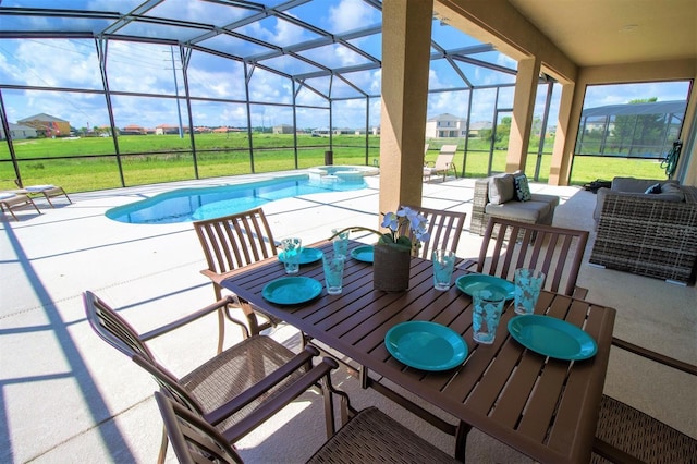 view of swimming pool featuring glass enclosure, outdoor dining area, a pool with connected hot tub, a lawn, and a patio area