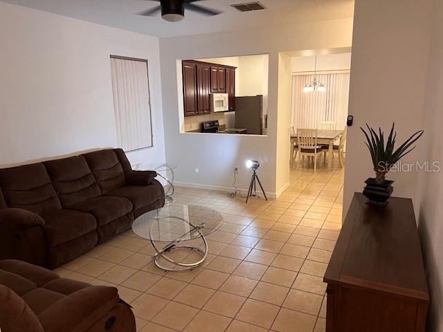 living room featuring light tile patterned floors and ceiling fan