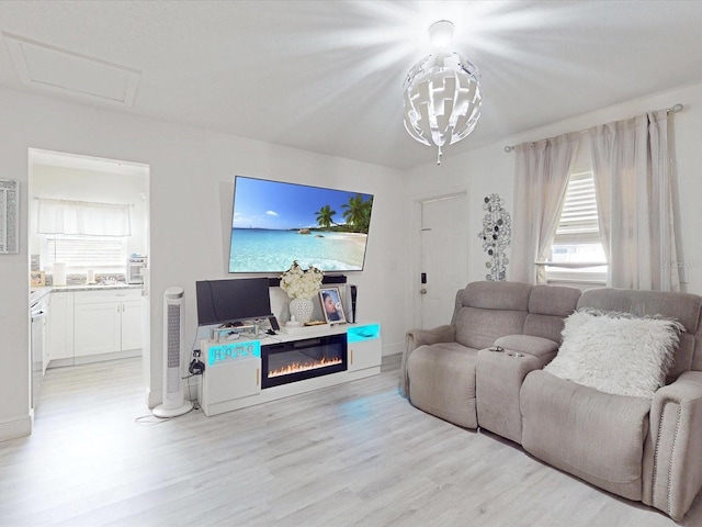 living room with a notable chandelier and light wood-type flooring