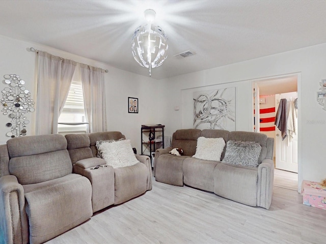 living room featuring an inviting chandelier and light wood-type flooring