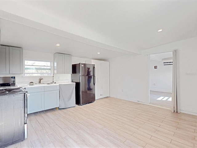 kitchen with black refrigerator, electric range oven, sink, dishwashing machine, and light hardwood / wood-style flooring