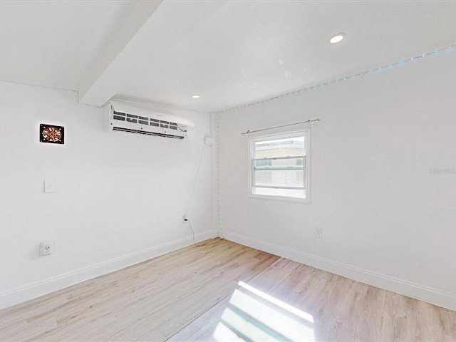 empty room featuring light hardwood / wood-style flooring and a wall mounted AC