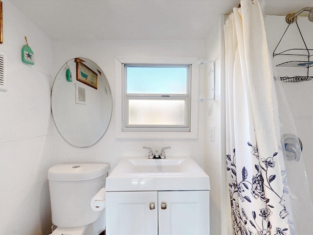 bathroom with vanity, toilet, and walk in shower