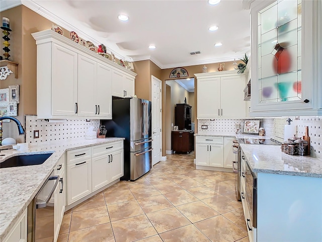 kitchen featuring sink, crown molding, stainless steel appliances, light stone countertops, and white cabinets