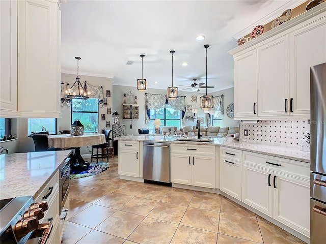 kitchen featuring white cabinetry, appliances with stainless steel finishes, sink, and hanging light fixtures