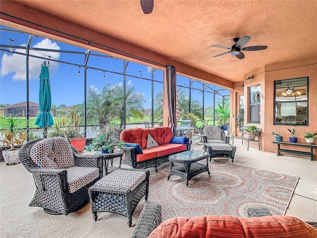 view of patio featuring ceiling fan, an outdoor hangout area, and glass enclosure