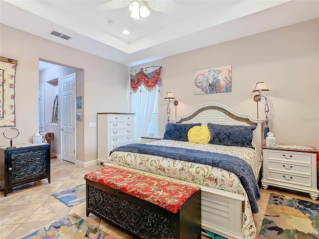 bedroom with ceiling fan, a raised ceiling, and light tile patterned floors