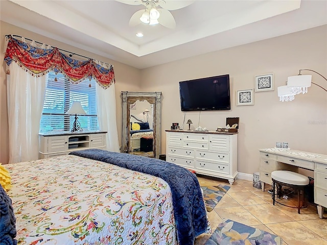 bedroom featuring light tile patterned floors, a raised ceiling, and ceiling fan