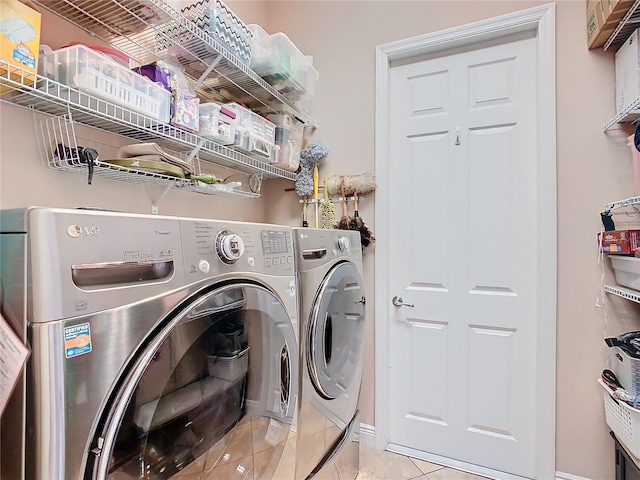 clothes washing area featuring washing machine and dryer and light tile patterned flooring