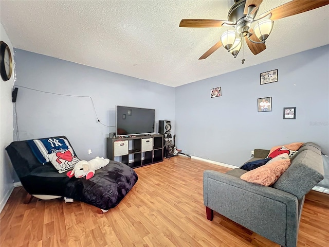 10409 Laxton St, Orlando, FL 32824 - living room with light wood-type flooring, ceiling fan, a textured ceiling, and baseboards