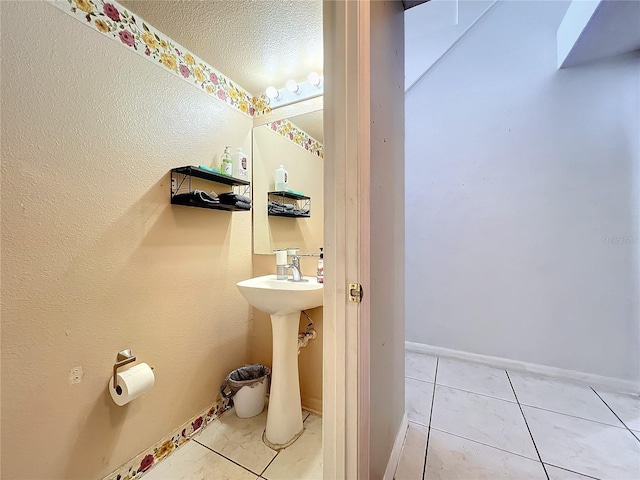 10409 Laxton St, Orlando, FL 32824 - bathroom with tile patterned flooring, a textured ceiling, a sink, and baseboards