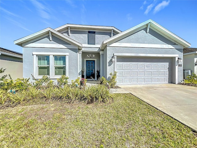 view of front of home featuring a garage, a front yard, concrete driveway, and stucco siding