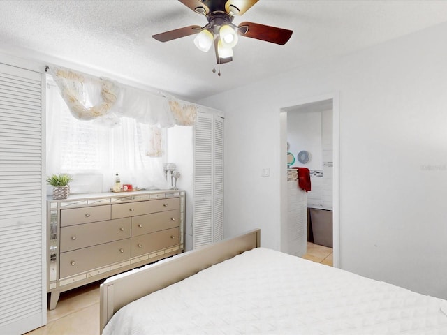 tiled bedroom featuring ceiling fan and a textured ceiling