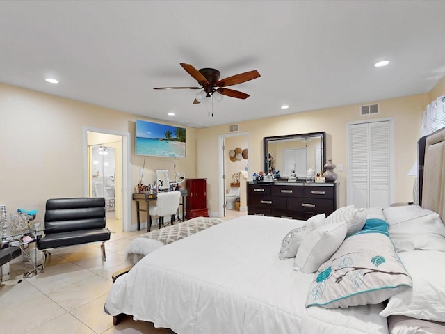 bedroom featuring light tile patterned flooring, ensuite bath, ceiling fan, and a closet