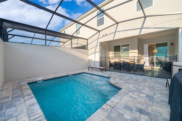 view of pool with a patio area and glass enclosure