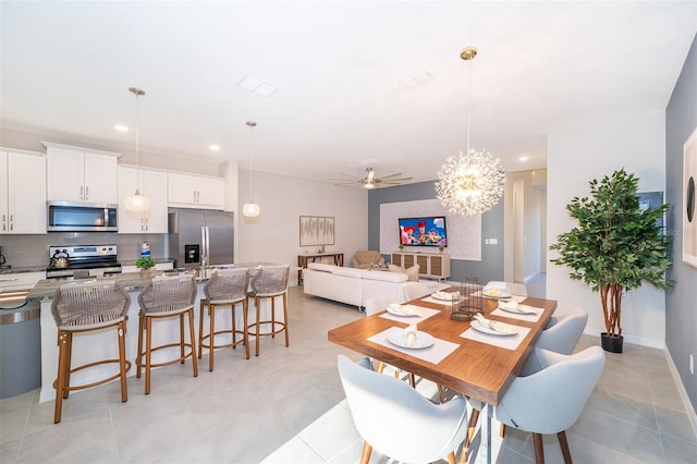 dining space with light tile patterned floors and ceiling fan with notable chandelier