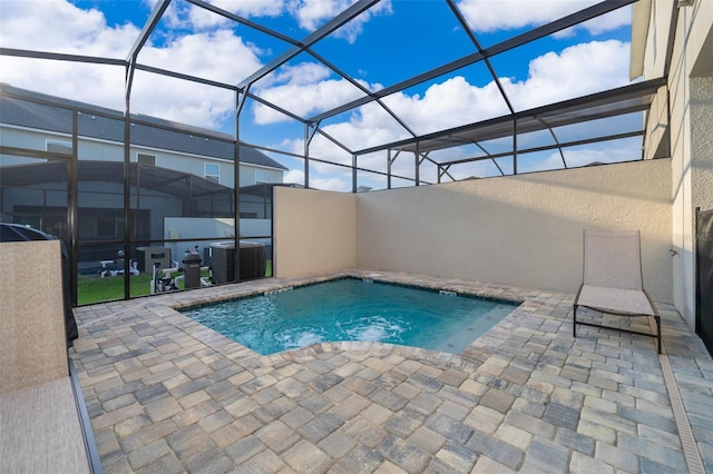 view of swimming pool with a patio, central AC, and glass enclosure