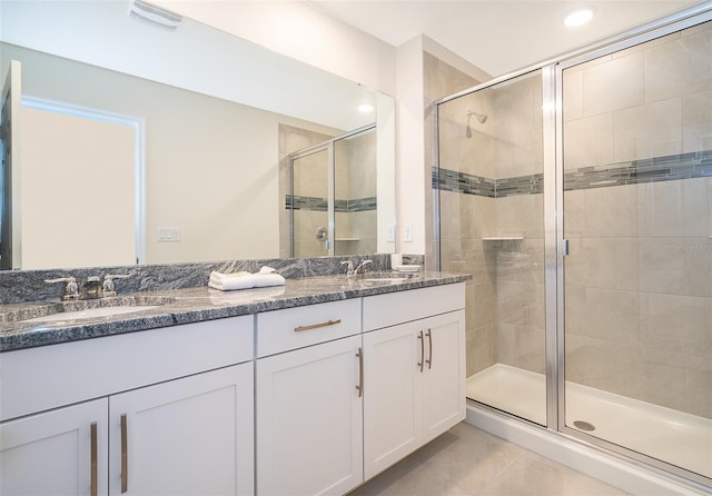 bathroom featuring vanity, tile patterned floors, and a shower with door