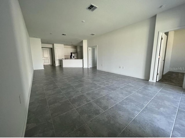 unfurnished living room with dark tile patterned floors