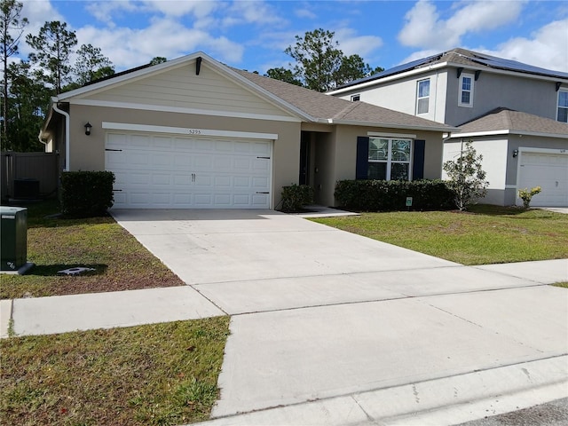 view of property with a garage and a front lawn