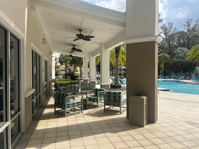 view of patio with a community pool and a ceiling fan
