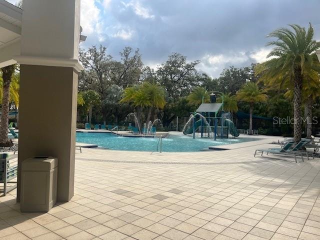 community pool featuring playground community and a patio