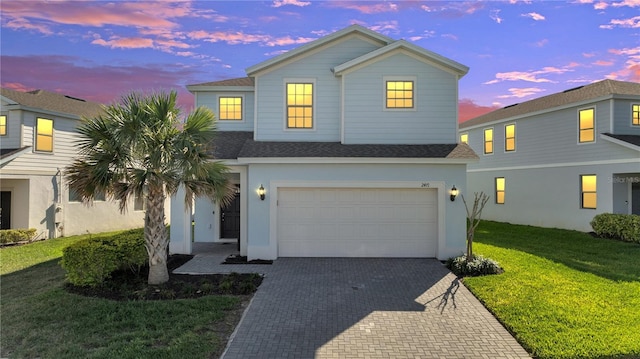 view of front of home with a garage and a yard