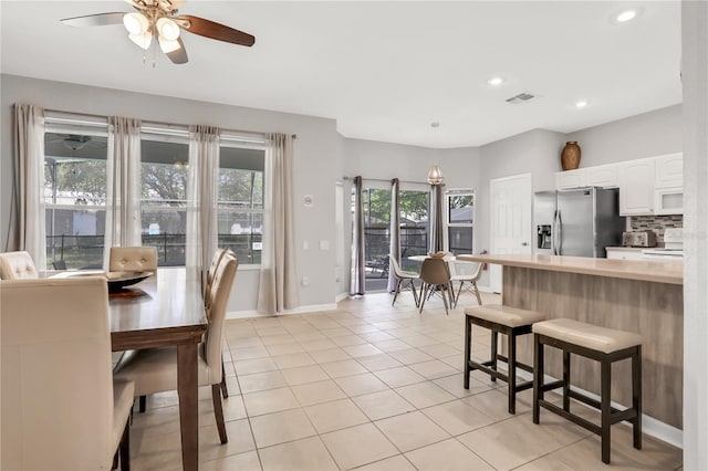 tiled dining space with ceiling fan