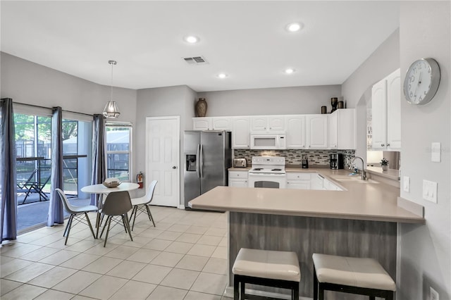 kitchen with sink, white cabinetry, decorative light fixtures, kitchen peninsula, and white appliances