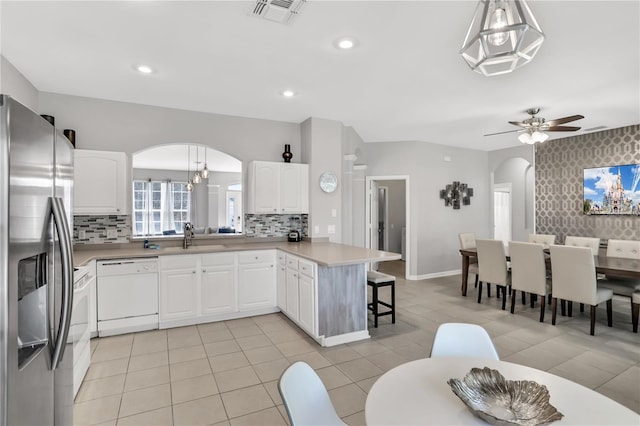 kitchen featuring kitchen peninsula, white cabinets, hanging light fixtures, white dishwasher, and stainless steel fridge with ice dispenser