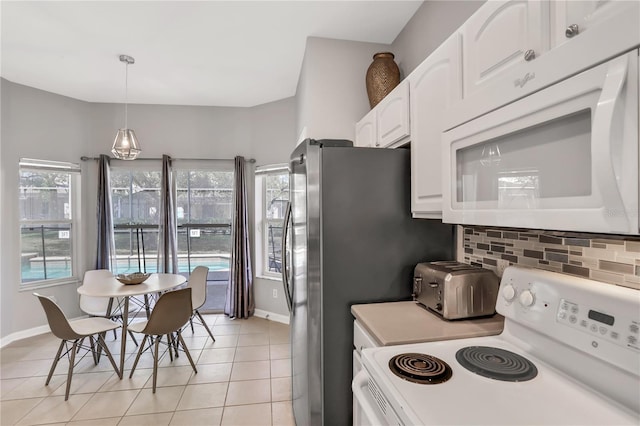 kitchen featuring white appliances, white cabinetry, hanging light fixtures, backsplash, and light tile patterned flooring