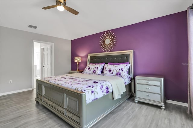 bedroom featuring wood-type flooring, connected bathroom, and ceiling fan