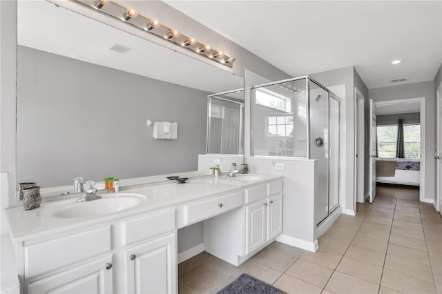 bathroom featuring vanity, a shower with shower door, and tile patterned flooring