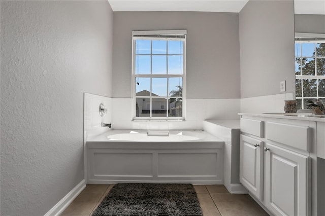 bathroom with vanity, a tub, and tile patterned floors