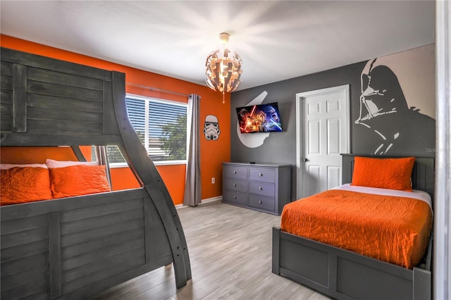 bedroom with light hardwood / wood-style floors and a chandelier