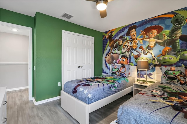 bedroom featuring wood-type flooring, a closet, and ceiling fan