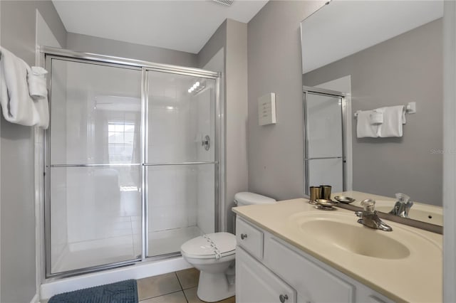 bathroom featuring vanity, a shower with door, tile patterned floors, and toilet