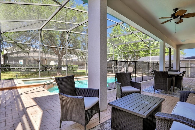 view of patio with ceiling fan, a swimming pool with hot tub, and a lanai