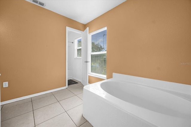 bathroom featuring tile patterned floors and tiled tub