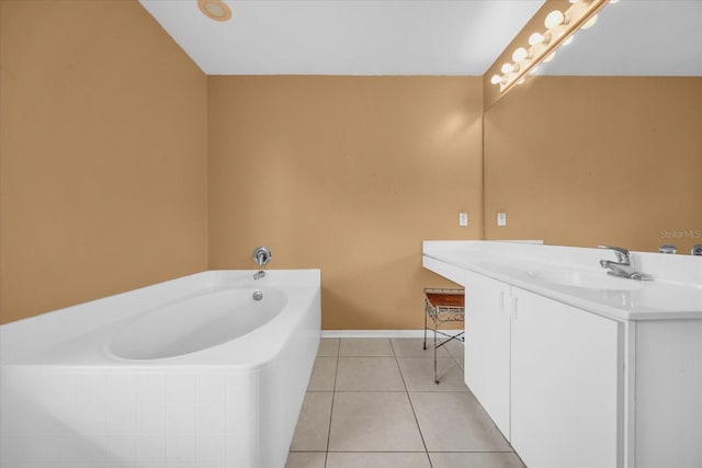 bathroom with tile patterned flooring, vanity, and tiled tub