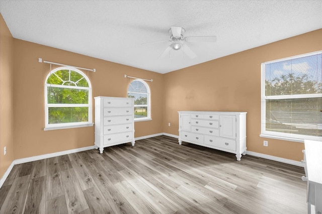 unfurnished bedroom with ceiling fan, light hardwood / wood-style floors, and a textured ceiling