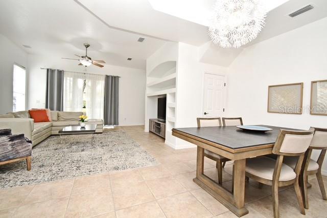 8766 The Esplanade Unit 23, Orlando, FL 32836 - dining area with light tile patterned flooring, ceiling fan with notable chandelier, and visible vents