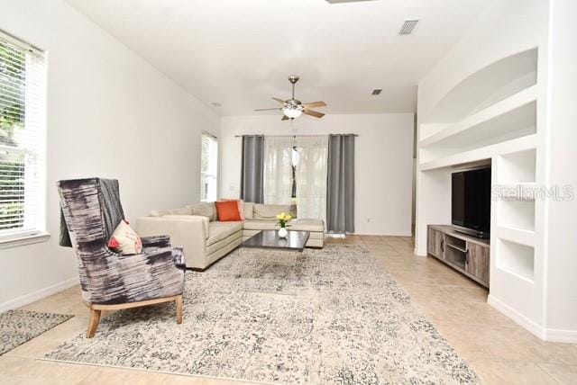8766 The Esplanade Unit 23, Orlando, FL 32836 - living room with light tile patterned flooring, baseboards, visible vents, and a ceiling fan